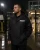 Security guard wearing a waterproof security rain jacket during rainy night duty at a gated entrance