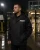 Security guard wearing a waterproof security rain jacket during rainy night duty at a gated entrance