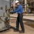 Worker wearing men’s FR stretch denim jeans while servicing valves at an industrial oil refinery.