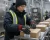 Female cold facility worker wearing insulated gloves while packing boxes on a production line