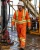 Oil rig worker wearing orange hi-vis FR coveralls on an offshore drilling platform
