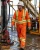 Oil rig worker wearing orange hi-vis FR coveralls on an offshore drilling platform