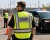 Sheriff deputy wearing a hi-vis safety vest while directing traffic near a patrol vehicle