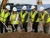 Crew wearing hi-vis safety vests at a construction groundbreaking ceremony