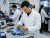 Engineer wearing an ESD anti-static lab coat while testing circuit boards and prototype electronics in an R&D lab