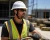Construction worker wearing a Type II full brim safety helmet on a jobsite.
