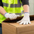 Warehouse worker wearing cotton knit work gloves handling boxes