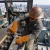 High-rise steel worker wearing leather welding gloves while fastening structural steel beams