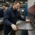 Metal fabrication worker wearing leather palm work gloves while handling sheet metal at press brake