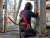 Worker wearing red welding safety harness while performing hot work on an elevated industrial platform