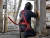 Worker wearing red welding safety harness while performing hot work on an elevated industrial platform