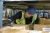 Warehouse worker wearing a blue bump cap while working under low-clearance shelving and equipment where stationary head bump hazards are present
