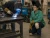 Worker wearing welding knee pads while welding metal in an industrial workshop.