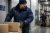 Worker wearing insulated freezer jacket while handling boxes in a cold storage warehouse rated for sub-zero conditions