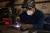 Welder wearing a disposable welding respirator mask while working with metal in an industrial fabrication