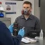 Worker conducting respirator fit testing with Allegro smoke tubes and a half-mask respirator in a workplace safety training setting