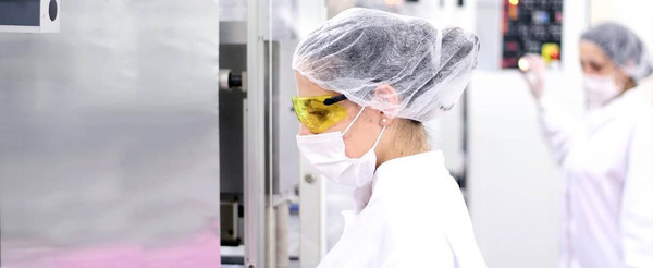 Manufacturing workers wearing disposable protective clothing