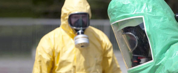 Workers wearing chemical protective suits and respiratory protection