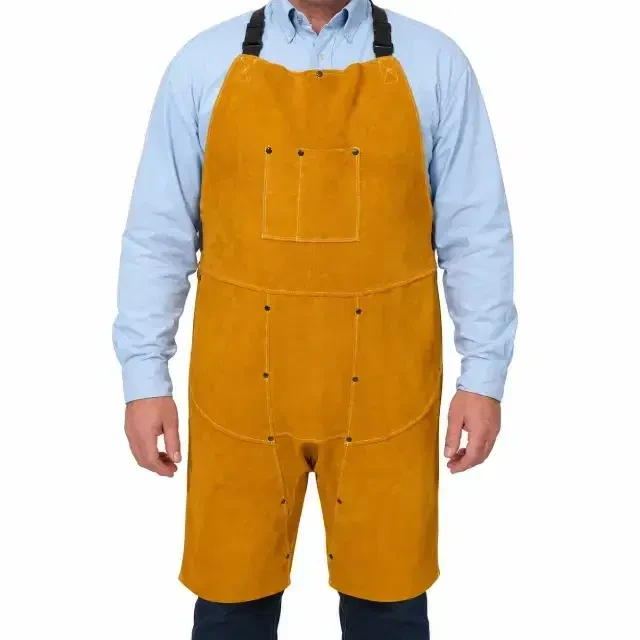 Worker wearing a golden leather welding apron with adjustable shoulder straps, utility pockets, and split-leg coverage for welding and metalworking tasks.