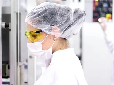 Manufacturing workers wearing disposable protective clothing