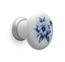 Gros plan du bouton en céramique blanche avec des fleurs Mital Design avec sa base en laiton naturel.