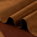 Gros plan sur la texture douce et l'élasticité du tissu suedette adhésif pour auto et DIY