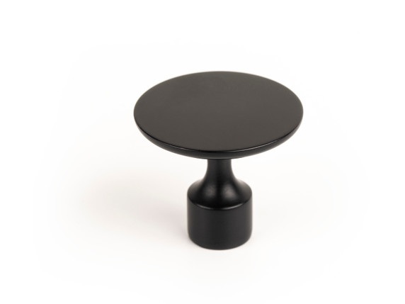 Gros plan du bouton Floid en zamak, mettant en évidence son design minimaliste et sa forme arrondie avec un pied cylindrique, dans l'une des quatre finitions disponibles (or brossé, noir mat, étain ou laiton antique)