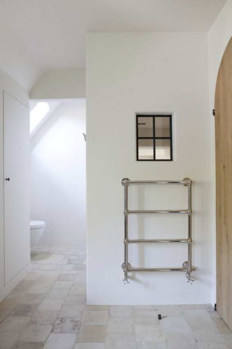 Porte-serviettes chauffant mural "Oxford" de Kenny & Mason, illustrant son design classique et sa fabrication en laiton massif.