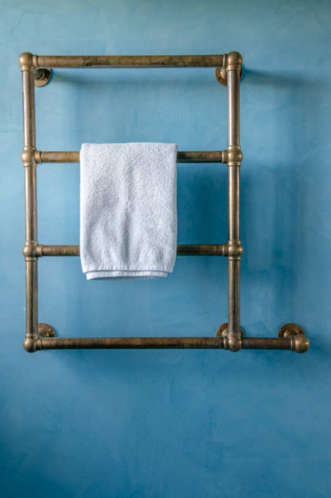 Porte-serviettes chauffant mural "Oxford" de Kenny & Mason, illustrant son design classique et sa fabrication en laiton massif.