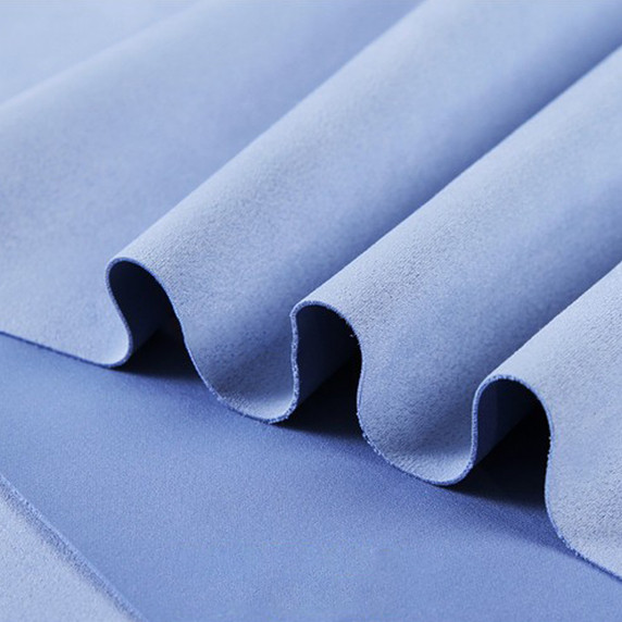 Gros plan sur la texture douce et l'élasticité du tissu suedette adhésif pour auto et DIY