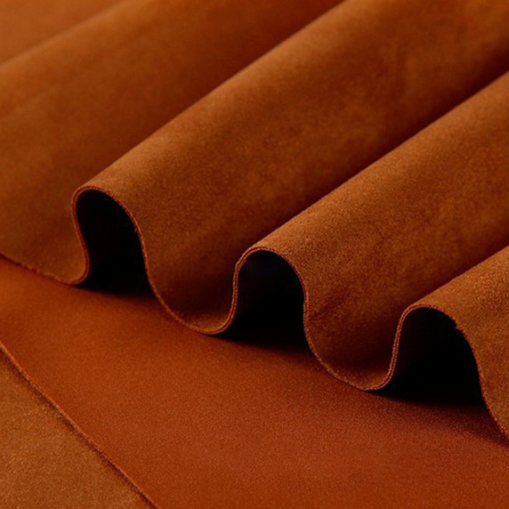 Gros plan sur la texture douce et l'élasticité du tissu suedette adhésif pour auto et DIY