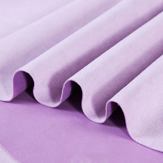Gros plan sur la texture douce et l'élasticité du tissu suedette adhésif pour auto et DIY