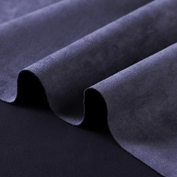 Gros plan sur la texture douce et l'élasticité du tissu suedette adhésif pour auto et DIY