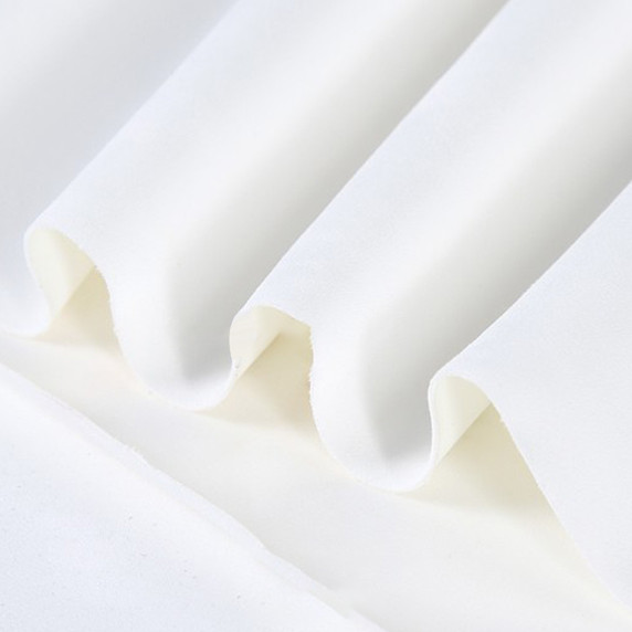 Gros plan sur la texture douce et l'élasticité du tissu suedette adhésif pour auto et DIY