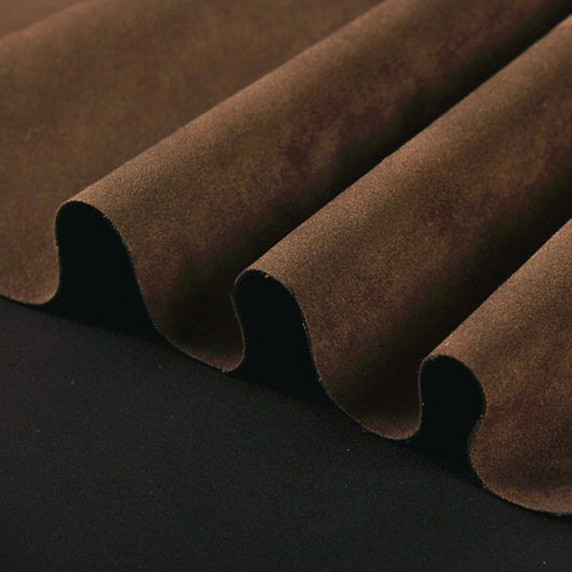 Gros plan sur la texture douce et l'élasticité du tissu suedette adhésif pour auto et DIY