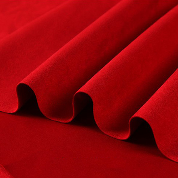 Gros plan sur la texture douce et l'élasticité du tissu suedette adhésif pour auto et DIY