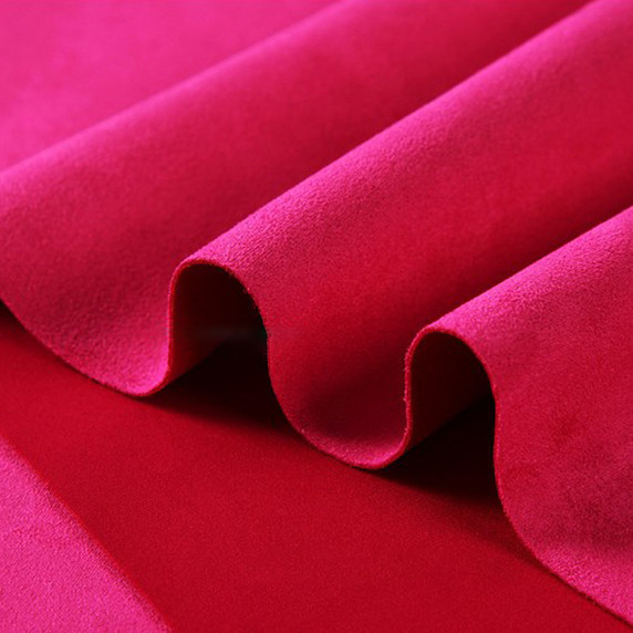 Gros plan sur la texture douce et l'élasticité du tissu suedette adhésif pour auto et DIY