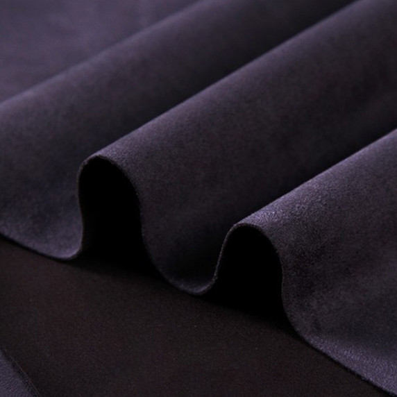 Gros plan sur la texture douce et l'élasticité du tissu suedette adhésif pour auto et DIY