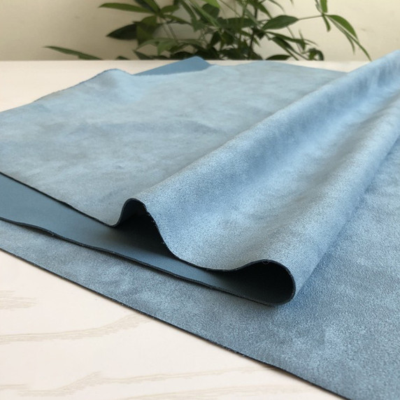 Gros plan sur la texture douce et l'élasticité du tissu suedette adhésif pour auto et DIY