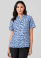 A woman wearing a short-sleeved tunic in a blue stardust print, featuring a collar and a relaxed fit.