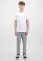 A pair of grey track pants with ribbed cuffs, displayed on a model wearing a white t-shirt and black shoes.
