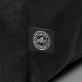 A black backpack made from recycled ocean plastic with a small logo patch.