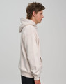 A unisex premium fleece oversized hoodie in a light beige colour, featuring a hood and side pockets.