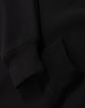 A black unisex premium fleece oversized hoodie with ribbed cuffs. The fabric appears soft and cozy.