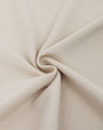 A close-up of light beige fabric, showcasing a textured cotton/poly pique weave. The fabric is folded in a spiral pattern.