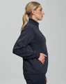 A woman in a side profile wearing a dark grey unisex premium fleece half zip sweatshirt, featuring a pocket.