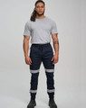 Cotton stretch drill cuffed work pants in navy blue with reflective tapes, worn by a model.
