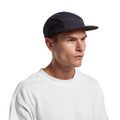 A cap in navy blue with a mesh design, featuring a branded logo, worn by a model with a neutral expression.