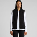 A black heavy vest with two front pockets, worn over a white long-sleeve top. Features branding.