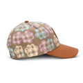 A cap featuring a full-colour patch design with pastel coloured paw prints on a beige background and a brown brim.